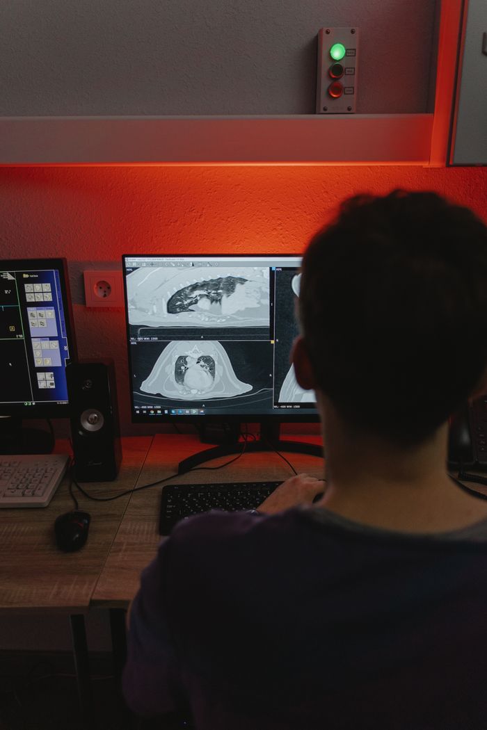 Mastering the First Impression: Your intriguing post title goes here A medical professional studies CT scans on multiple monitors in a dimly lit medical office.